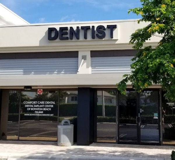 The image shows a storefront with the sign Dentist prominently displayed above a glass door.